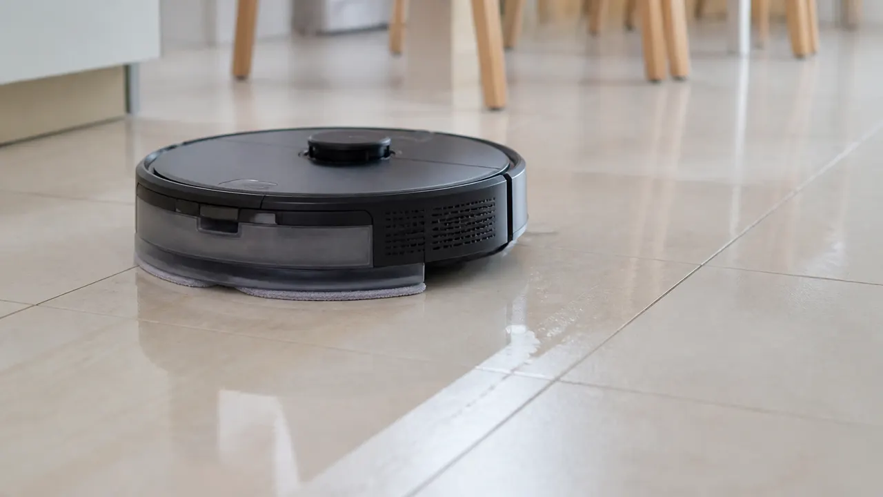 Robot aspirateur laveur passant la serpillière humide sur un carrelage de cuisine