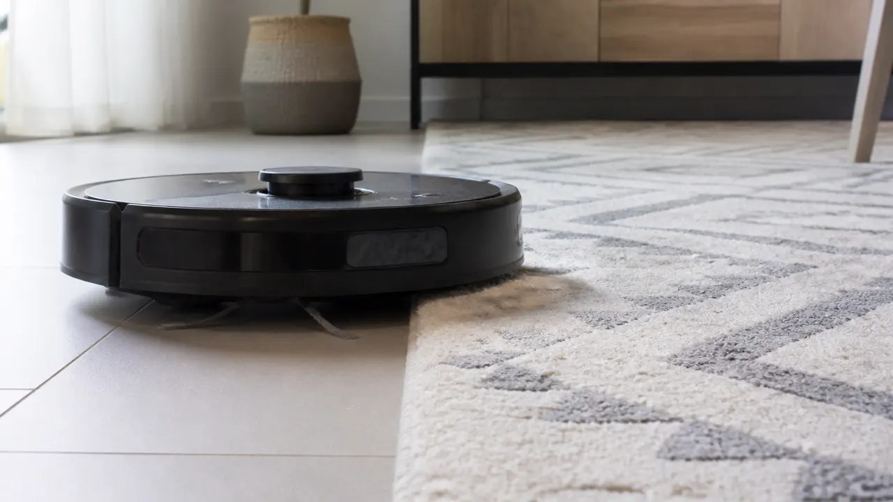 Robot laveur face à un tapis épais Robot aspirateur laveur stoppé devant un tapis épais